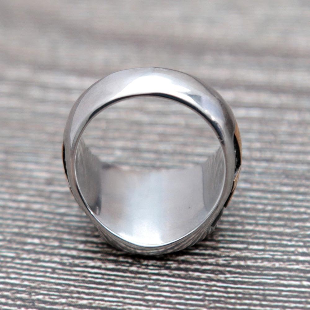 Anel masculino Olho de Hórus em aço inoxidável, exibido de um terceiro ângulo em fundo cinza, enfatizando o acabamento em esmalte preto e o design do símbolo