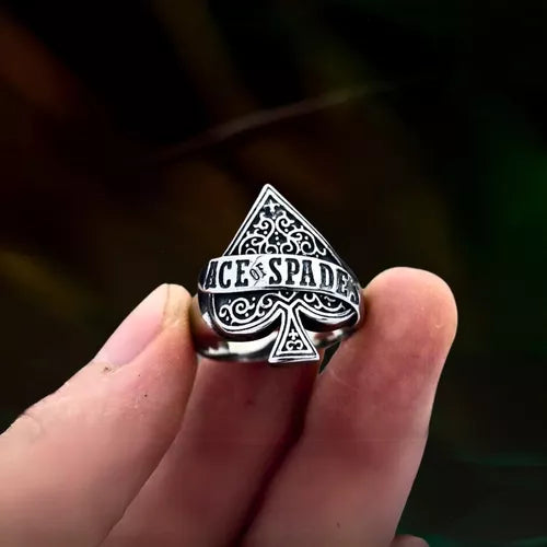 Anel masculino Ás de Espadas em aço prata, sendo segurado na ponta dos dedos para destacar os detalhes do símbolo do Ás.
