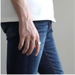 Anel masculino Flat Clássico em aço inoxidável prata sendo usado com uma camisa branca e calça jeans, destacando seu visual casual