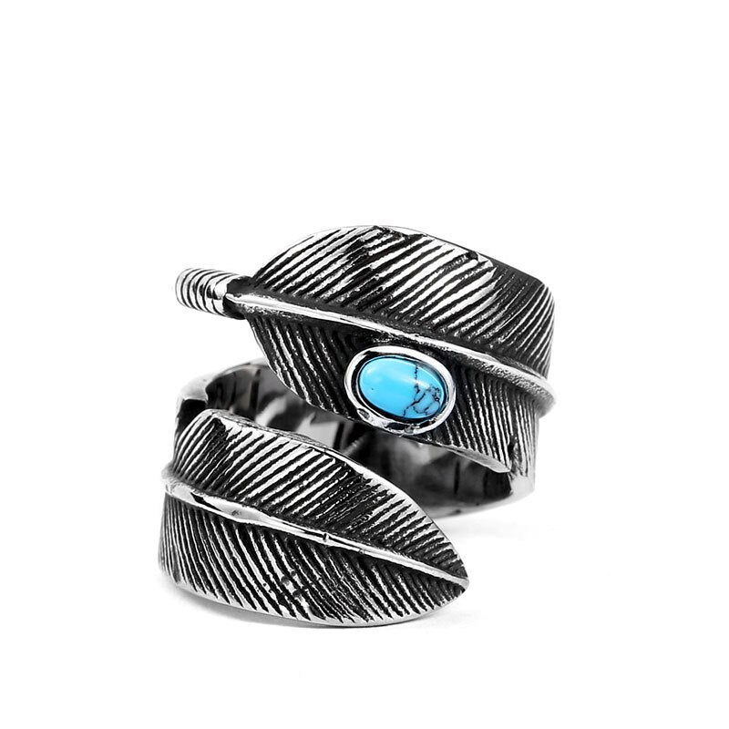 Anel masculino Pluma Turquesa em aço prata com detalhe de pena e pedra turquesa, exibido em fundo branco para destacar os detalhes do design.