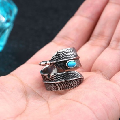 Anel masculino Pluma Turquesa em aço prata com detalhes de pena e pedra turquesa, mostrado na mão para destacar seu estilo vintage