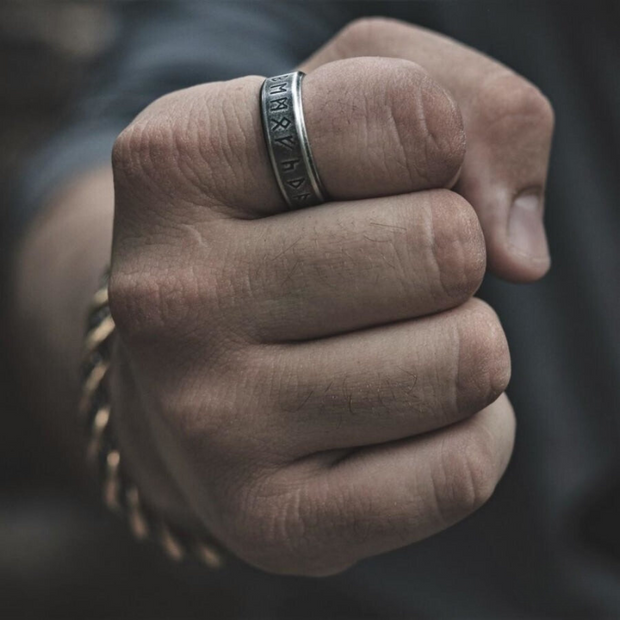 Anel masculino Norse Runes Viking em aço prata, sendo usado na mão, simbolizando força e poder