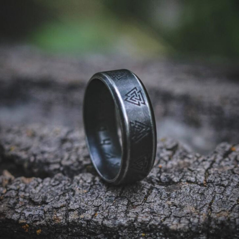 Anel masculino Norse Runes Viking em aço prata com Valknut, exibido em pé, destacando os detalhes simbólicos