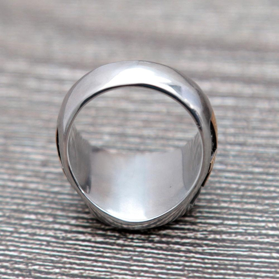Anel masculino Olho de Hórus em aço inoxidável, exibido de um terceiro ângulo em fundo cinza, enfatizando o acabamento em esmalte preto e o design do símbolo