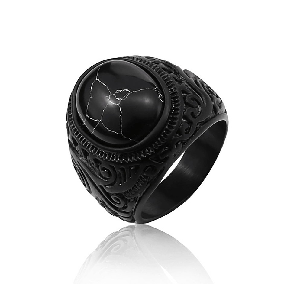 Anel masculino Inca Black em aço inoxidável com pedra texturizada, exibido em fundo branco, destacando os detalhes da pedra e o acabamento preto do anel.