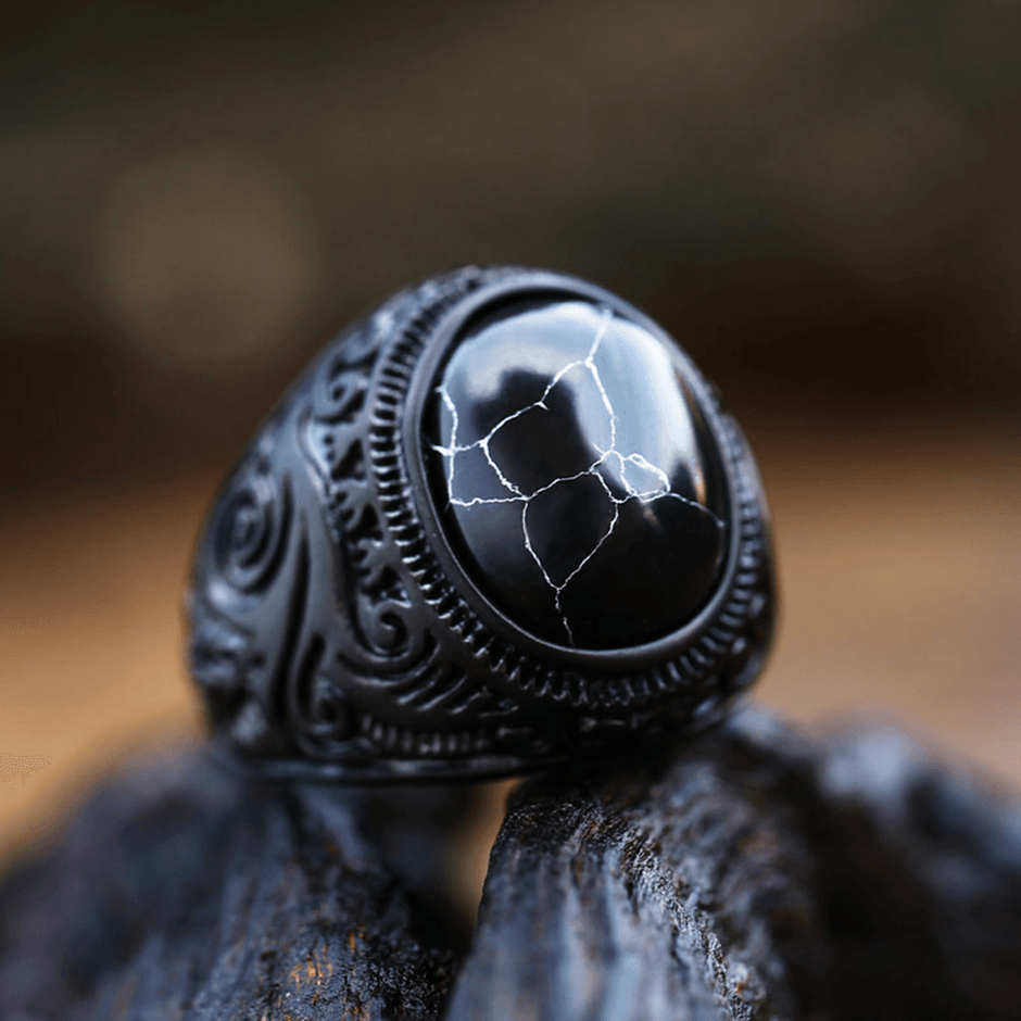 Anel masculino Inca Black com pedra texturizada, exibido em fundo preto, capturado de um ângulo lateral para destacar os detalhes do design.