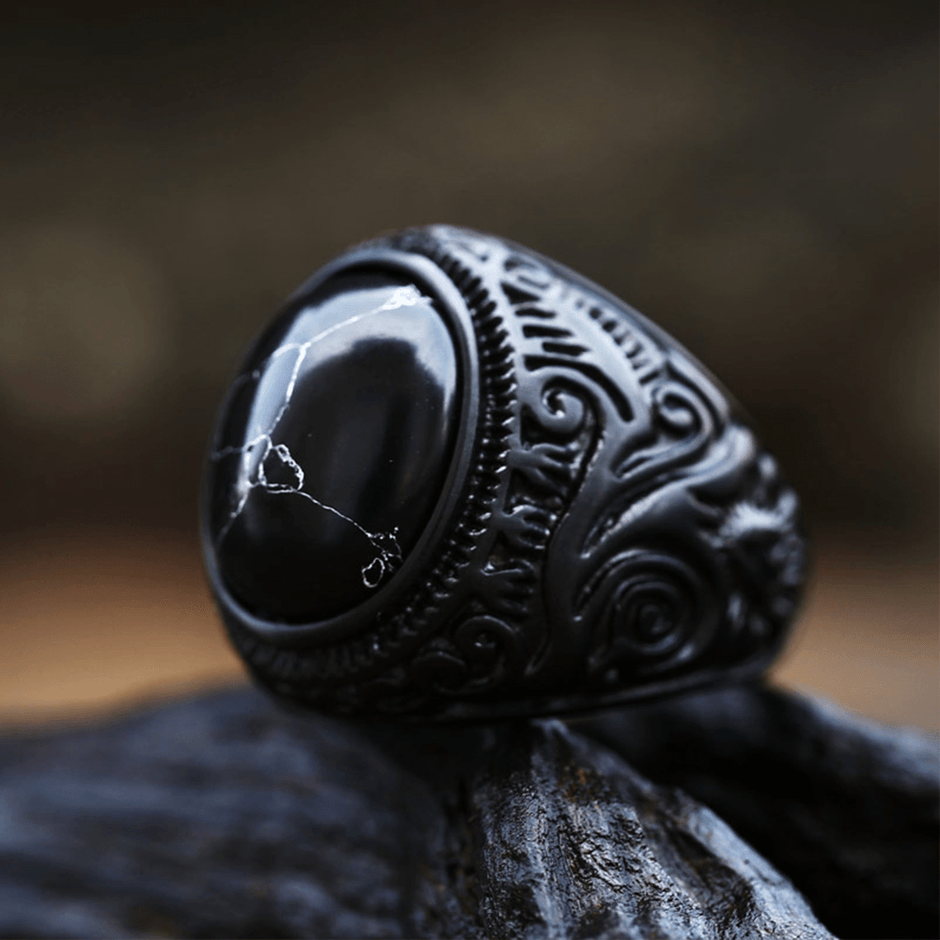 Anel masculino Inca Black com pedra texturizada, exibido de um terceiro ângulo em fundo preto, destacando a textura da pedra e o acabamento escuro do anel.