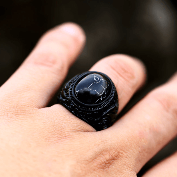 Anel masculino Inca Black com pedra texturizada em aço inoxidável, sendo usado no dedo, mostrando o design e a textura única da pedra.
