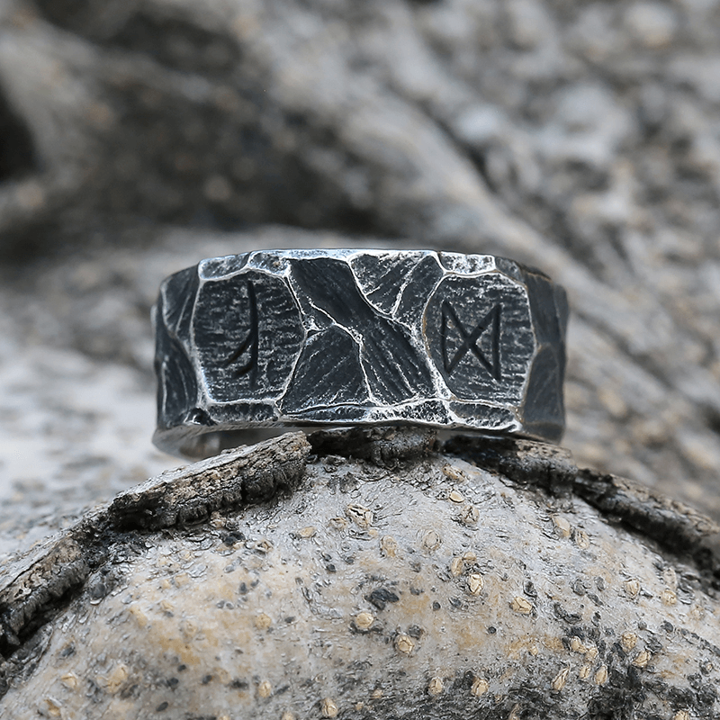 Anel masculino Viking rústico em aço prata, apresentado sobre fundo rochoso claro para capturar sua aparência autêntica e estilo viking único